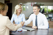 © sepy - Handshake. Shot of an investment advisor shaking hands with smiling man while consulting with middle aged couple about financial savings.