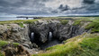 Dungeon national Park, Newfoundland featuring a rare natural occurrence of rock formation under which, two tunnels comprise a haunting face - earning it its local nickname, Devil's eyes.