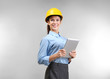© Africa Studio - Confident young woman with hardhat and tablet computer, on light background