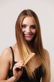 Fototapeta Zachód słońca - Woman combing her long hair with wooden comb