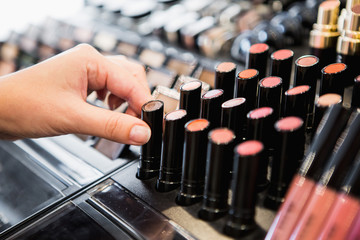 woman chooses lipstick in store