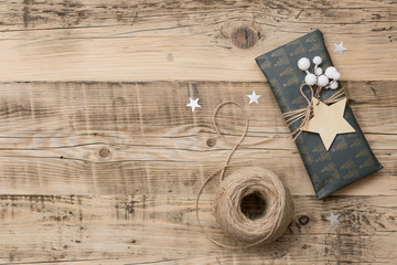 Wall Mural - Top view on nice Christmas gifts packed in black and striped paper and decorated with stars on wooden background. Presents and decor elements. Holidays and winter concept.