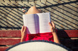 © narstudio - Top view of a woman reading a book.