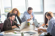 © Svyatoslav Lypynskyy - Business people communicating in board room in office interior. Happy colleagues happy working all together showing teamwork. Teamwork concept.