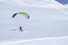 Green Skier Finish With A Paraglider