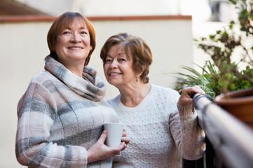 Wall Mural - Portrait of happy female pensioners drinking tea and smiling