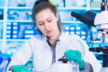 Wall Mural - woman in a laboratory with microtube test tube in hand and PCR centrifuge. scientist using a centrifuge in a laboratory