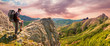 Hiker on the top enjoys mountains panorama landscape before sunrise