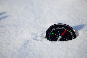 the compass lies on snow and specifies the direction