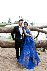 Wall Mural - Bride and groom on their wedding day outdoors. Chinese bride in a blue dress