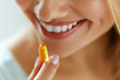 Close Up Of Beautiful Woman Taking Fish Oil Capsule In Mouth