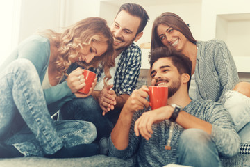 Cheerful group of friends having fun at home