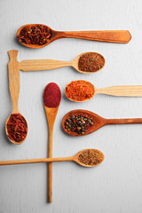 Wall Mural - Spices in spoons on a wooden background