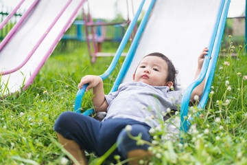 Wall Mural - Little Asian kid playing slide at the playground