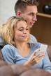 © eric - Couple At Home In Lounge Using smartphone