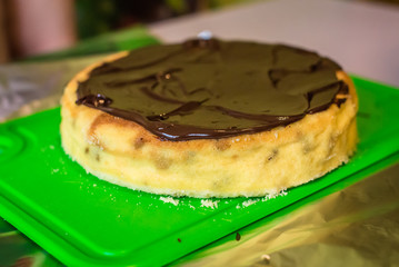 warm delicious cheesecake with liquid chocolate on a green board