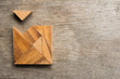 Wooden tangram with one piece is wait to fulfill the square shap