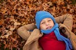 © WavebreakMediaMicro - High angle portrait of boy lying at park during autumn