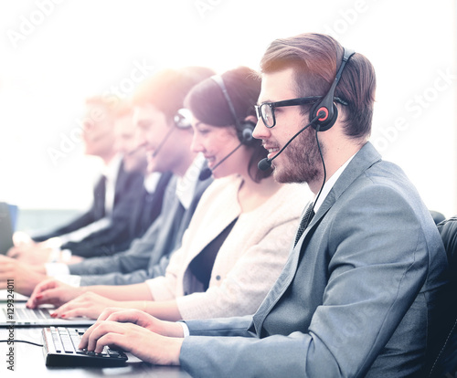 Fotografía Attractive young man working in a call center with his colleagues