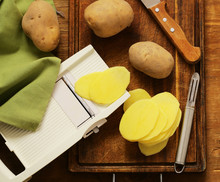 Peeled And Sliced Raw Potatoes On A Cutting Board