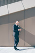 © Eugenio Marongiu - Middle-age contemporary businessman outdoor in the city, using smart phone hand hold - business, work, communication concept