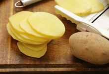 Peeled And Sliced Raw Potatoes On A Cutting Board