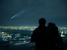 Couple Looking Over Osaka Night Skyline And Falling Stars