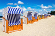 Blue and white wicker chairs on sandy beach