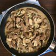 Beef Stroganoff in frying pan, a dish made of pieces of beef, mushroom and onion in cream sauce, photographed overhead with natural light