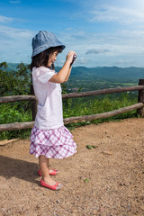 Wall Mural - Happy asian girl smiling and relaxing outdoors in the daytime