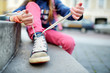 © MNStudio - Cute little girl learning to tie shoelaces outdoors