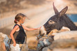 Little girl with donkey on the island of Mykonos