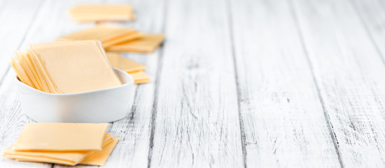 Wall Mural - Portion of Cheese slices on wooden background (selective focus)