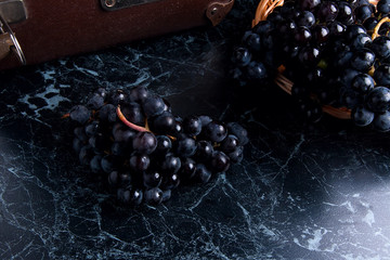 Cluster of blue grapes on dark marble background. Vintage case o