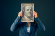 Businesswoman holding Benjamin Franklin 100 USA dollar portrait