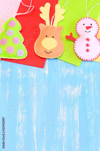 Download Christmas Tree Decorations Funny Felt Reindeer Head Christmas Tree Snowman Decorations Flat Felt Pieces On A Blue Wooden Background With Copy Space For Text Kids Christmas Background Top View Buy This PSD Mockup Templates