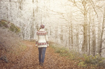 Young girl walking on a forest road/Young girl walking on a forest road in a beautiful knitted winter sweater