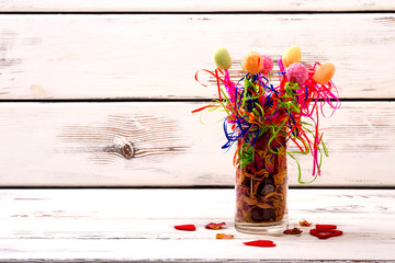 Vase with potpourri and candies. Sweets and dried rose petals. Creative cooking and serving. Making special present.