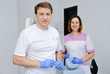 © Evgeniy Kalinovskiy - Male dentist with assistant medical instruments and girl on the background of the clinic