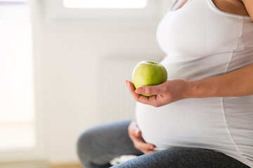 Wall Mural - Pregnant woman eating apple