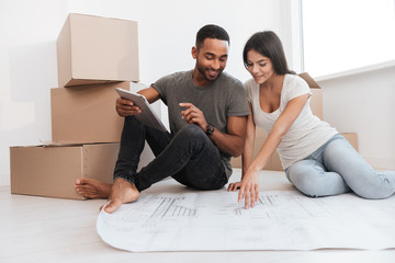 Wall Mural - Couple planning decoration at new home sitting on the floor