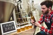 © WavebreakMediaMicro - Manufacturer examining beer in brewery