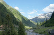 Berglandschaft in Graubünden, Schweiz/Blick in ein Tal mit einem Gebirgsbach, hohe Berge teilweise mit Schnee, Landschaft in Graubünden