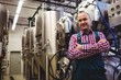 © WavebreakMediaMicro - Mature manufacturer standing by storage tank in brewery