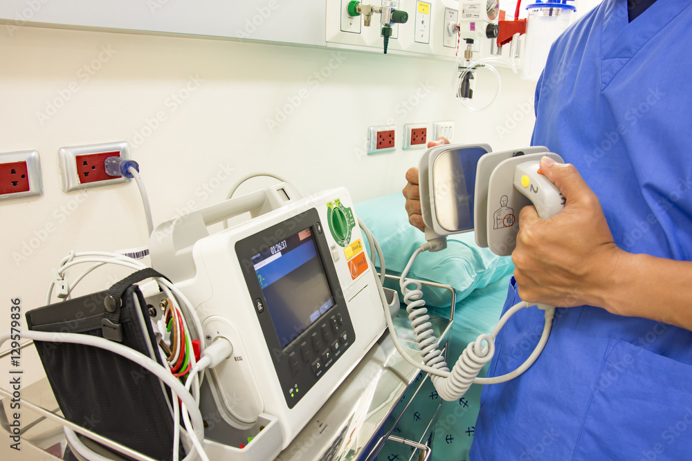 doctor use EKG or ECG and test defibrillator system in emergency - obrazy, fototapety, plakaty 