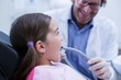 © WavebreakMediaMicro - Dentist examining a young patient with tools