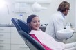 © WavebreakMediaMicro - Smiling young patient sitting on dentists chair