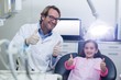 © WavebreakMediaMicro - Smiling dentist and young patient showing thumbs up