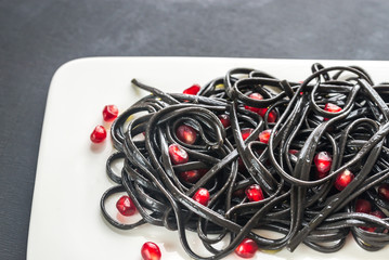 Sticker - Black pasta with pomegranate seeds