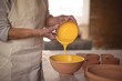 © WavebreakMediaMicro - Mid section of female potter pouring watercolor in bowl